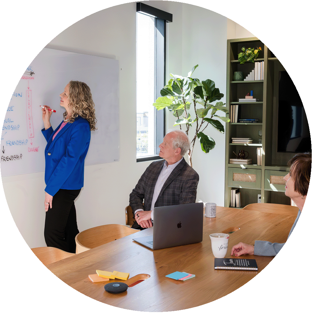 Woman leading a workshop in a bright, modern office setting with colleagues.