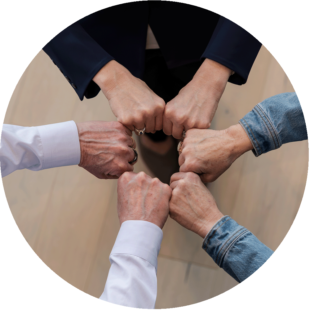Group of diverse women and men forming a fist bump for teamwork.